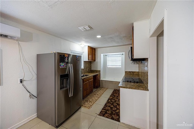 3300 N 20th St, Mcallen, TX 78501 - kitchen with stainless steel fridge, black electric stovetop, a wall mounted air conditioner, a textured ceiling, and light tile patterned floors