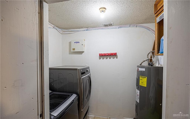 washroom featuring washer and clothes dryer, a textured ceiling, and water heater