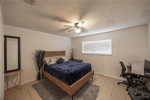 tiled bedroom with a textured ceiling and ceiling fan