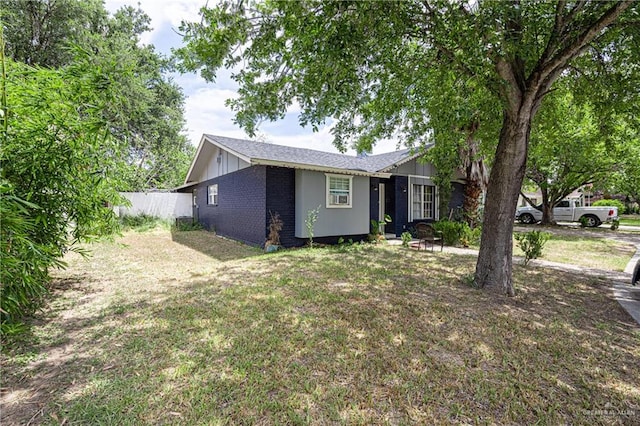 single story home with a front lawn and an outdoor fire pit