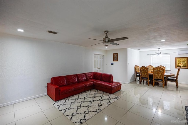 living room with a wall mounted AC, light tile patterned floors, and ceiling fan with notable chandelier