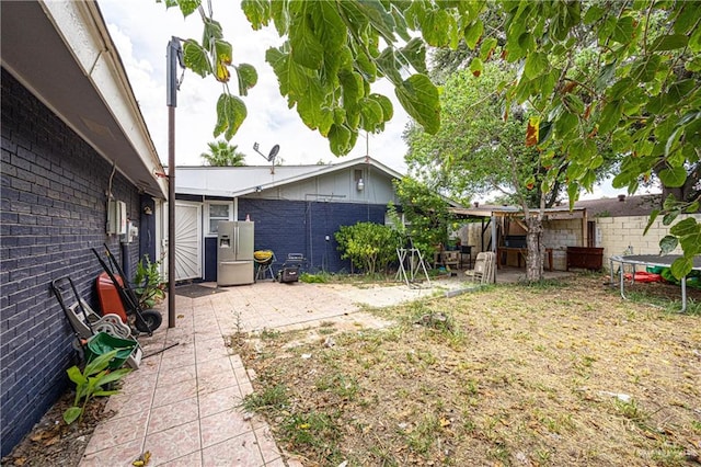 view of yard featuring a patio and a trampoline