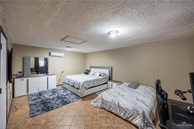 bedroom with a wall mounted air conditioner, light tile patterned floors, and a textured ceiling