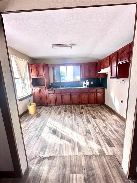 kitchen featuring a textured ceiling and hardwood / wood-style flooring