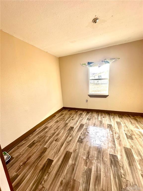 spare room with hardwood / wood-style floors and a textured ceiling