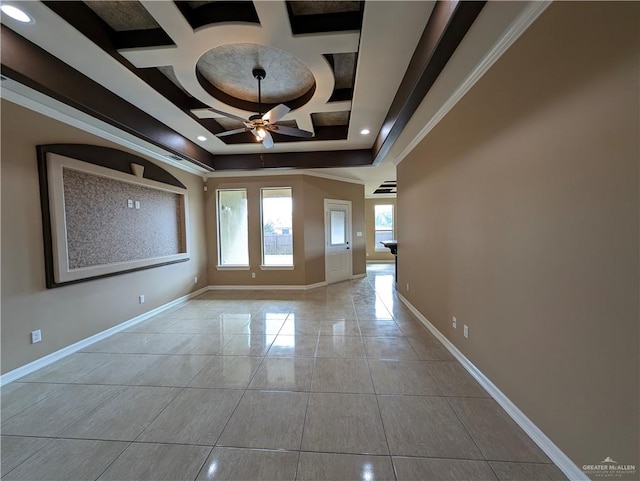 unfurnished room featuring ceiling fan, coffered ceiling, crown molding, a tray ceiling, and light tile patterned floors