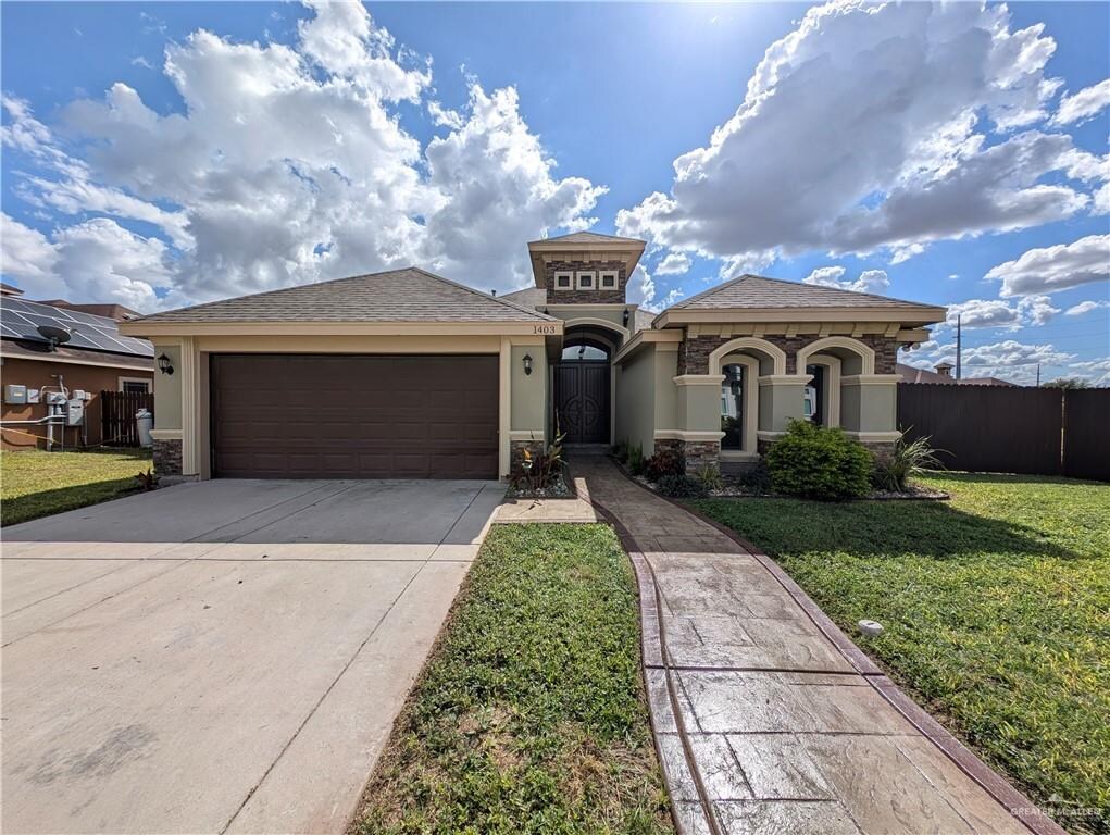 view of front of home with a front yard and a garage