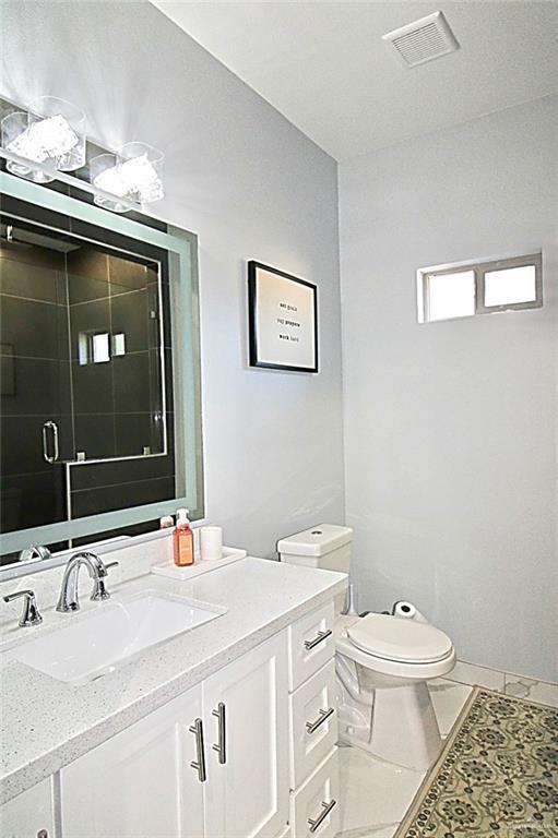 2209 David Ave, San Juan, TX 78589 - bathroom featuring a shower stall, visible vents, vanity, and toilet