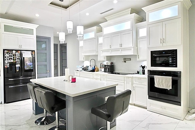 2209 David Ave, San Juan, TX 78589 - kitchen featuring recessed lighting, marble finish floor, a breakfast bar, a center island, and black appliances