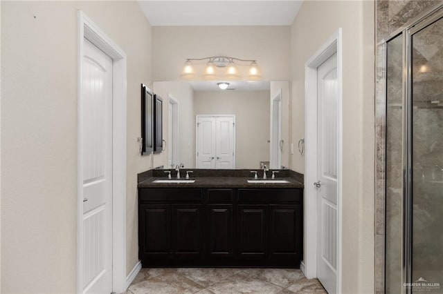 bathroom with double vanity, a shower stall, and a sink