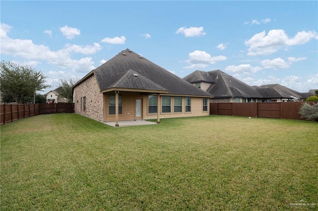 rear view of house with a yard and a fenced backyard