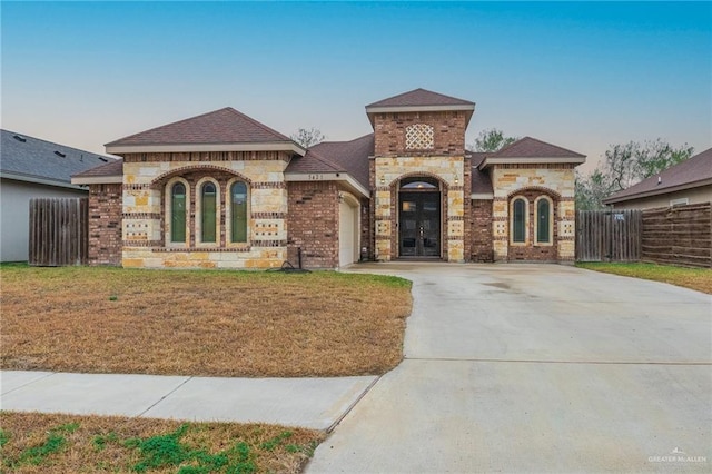 mediterranean / spanish-style home with a garage and a front lawn