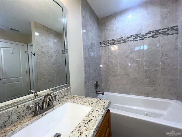 bathroom featuring vanity and tiled shower / bath