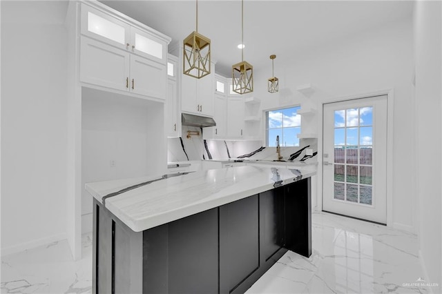 2208 Trinity St, Donna, TX 78537 - kitchen with under cabinet range hood, open shelves, light marble finish flooring, white cabinetry, and hanging light fixtures