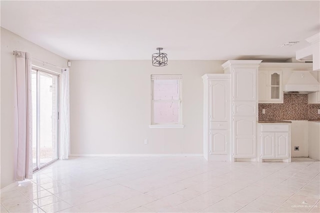 interior space featuring light tile patterned floors, visible vents, and baseboards