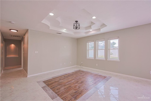 unfurnished room featuring light tile patterned floors, a raised ceiling, visible vents, baseboards, and recessed lighting