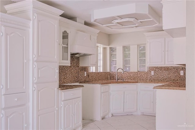 kitchen featuring white cabinetry, backsplash, and a sink