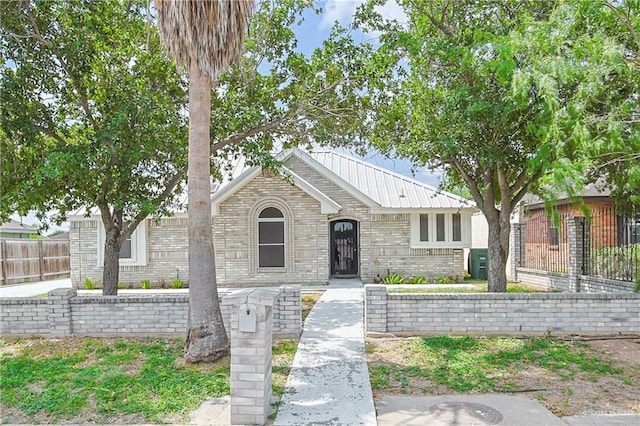 view of front of home featuring fence, central AC unit, brick siding, and metal roof