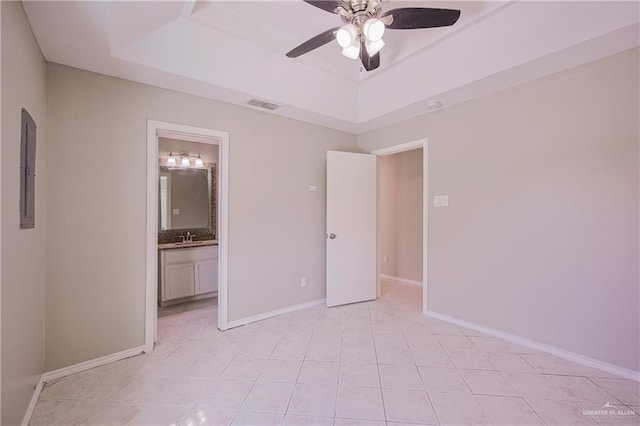 unfurnished bedroom featuring a sink, baseboards, visible vents, a raised ceiling, and light tile patterned flooring