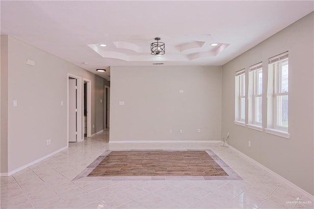 unfurnished room with baseboards, recessed lighting, and a tray ceiling