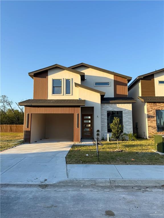 contemporary home with driveway, central AC, and an attached garage