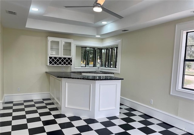5307 Fm 493rd Rd, Donna, TX 78537 - kitchen with tile patterned floors, a tray ceiling, white cabinets, glass insert cabinets, and a ceiling fan