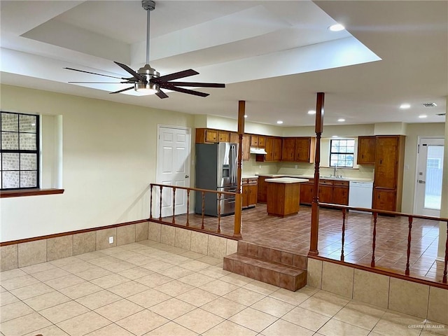 5307 Fm 493rd Rd, Donna, TX 78537 - kitchen with stainless steel fridge with ice dispenser, a raised ceiling, light tile patterned flooring, dishwasher, and brown cabinetry