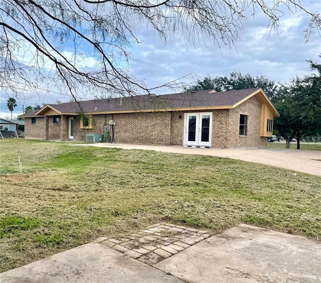 5307 Fm 493rd Rd, Donna, TX 78537 - rear view of house with french doors, brick siding, and a lawn