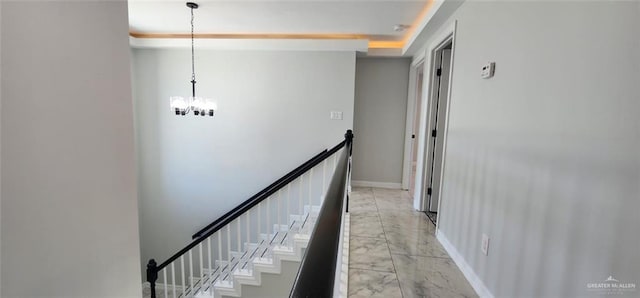 hall featuring baseboards, a notable chandelier, and marble finish floor