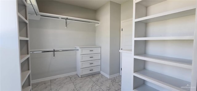 walk in closet featuring marble finish floor