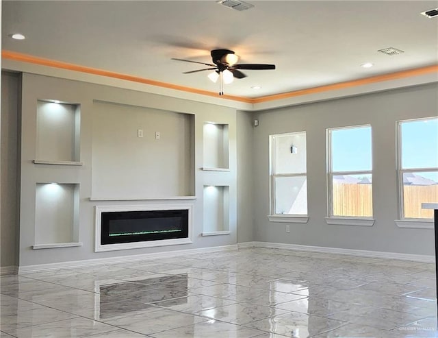 unfurnished living room featuring ceiling fan, a glass covered fireplace, marble finish floor, baseboards, and visible vents