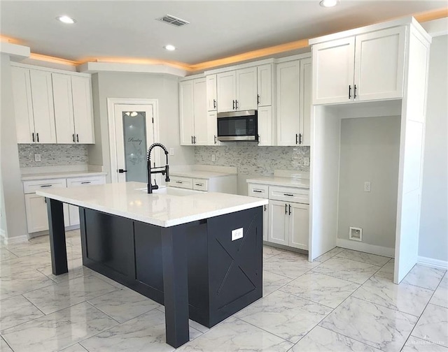 kitchen featuring visible vents, marble finish floor, recessed lighting, stainless steel microwave, and a sink