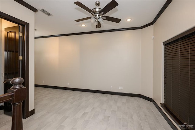 spare room featuring baseboards, light wood finished floors, visible vents, and crown molding