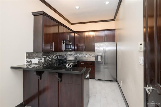 kitchen featuring dark countertops, dark brown cabinetry, ornamental molding, and stainless steel appliances