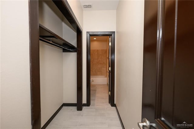 hallway featuring visible vents and baseboards