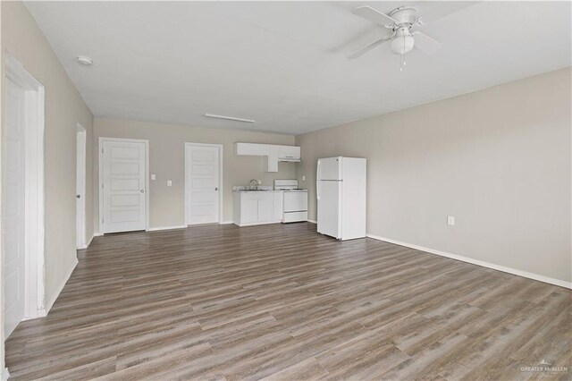 unfurnished living room with ceiling fan and wood-type flooring