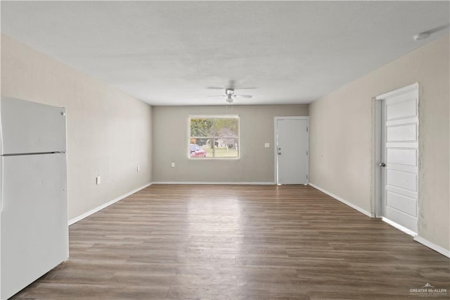 unfurnished living room featuring ceiling fan and dark wood-type flooring