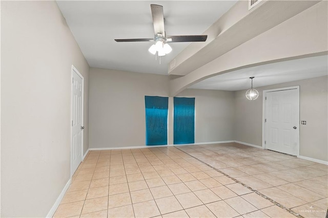 tiled spare room featuring ceiling fan with notable chandelier