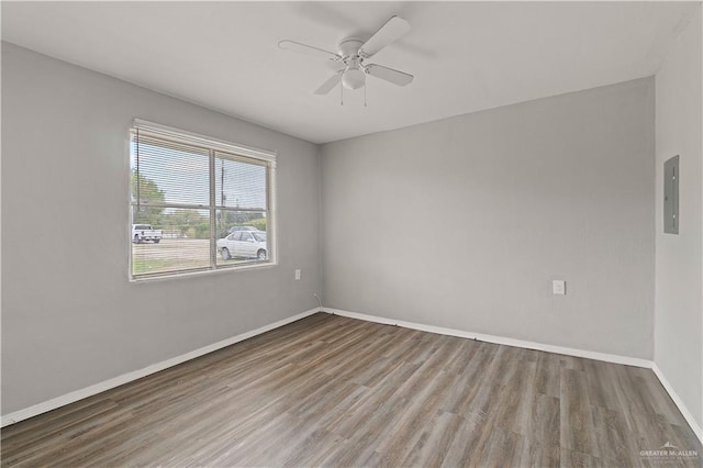 spare room featuring ceiling fan, wood-type flooring, and electric panel