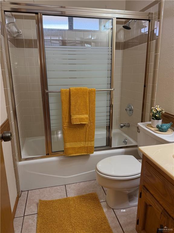 2303 Viola St, Mission, TX 78574 - full bathroom featuring toilet, enclosed tub / shower combo, tile patterned flooring, and vanity