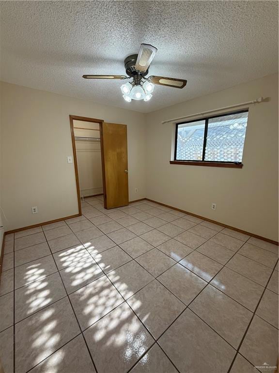 2303 Viola St, Mission, TX 78574 - unfurnished bedroom featuring light tile patterned floors, baseboards, a closet, and a textured ceiling