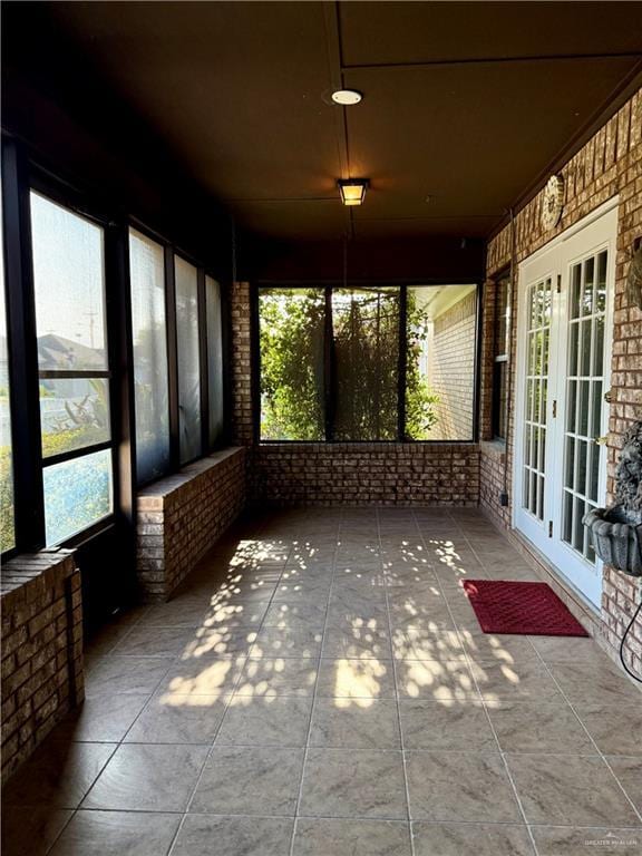 2303 Viola St, Mission, TX 78574 - unfurnished sunroom featuring tile patterned floors, a wealth of natural light, french doors, and brick wall