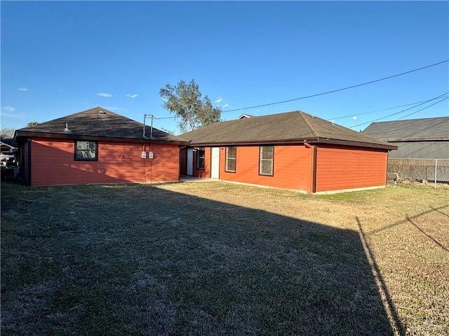 rear view of house featuring a yard