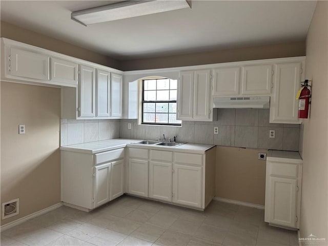 kitchen featuring white cabinets, light tile patterned flooring, decorative backsplash, and sink