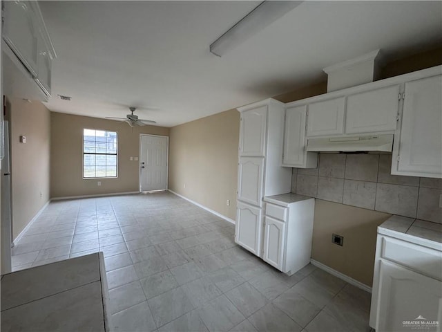 kitchen featuring backsplash, white cabinetry, and ceiling fan