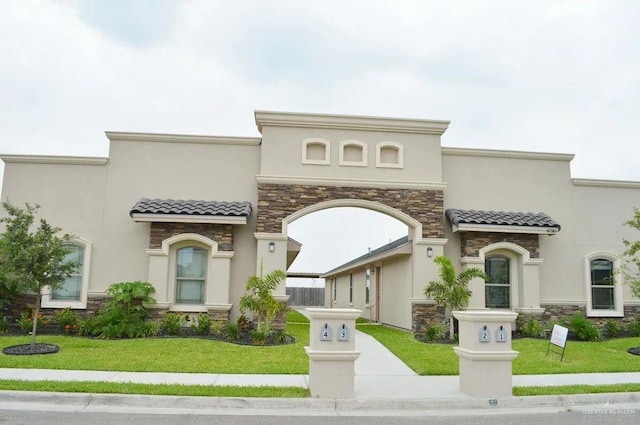 mediterranean / spanish-style home featuring a front yard