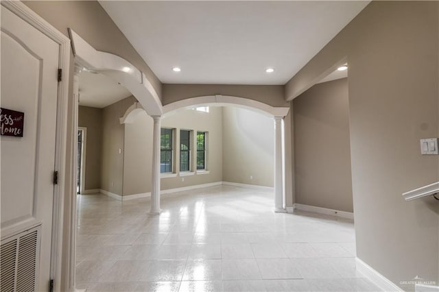 spare room with ornate columns, light tile patterned flooring, baseboards, and recessed lighting