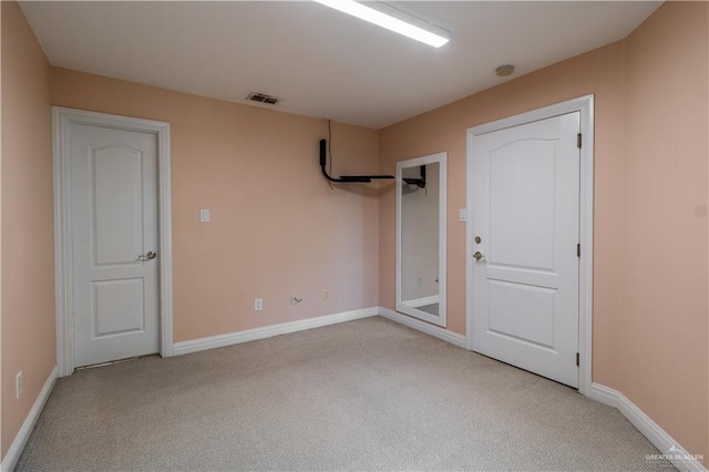 empty room featuring visible vents, baseboards, and light carpet