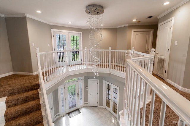 foyer with an inviting chandelier, recessed lighting, french doors, and crown molding