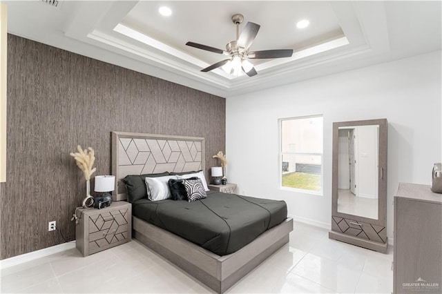 tiled bedroom featuring a raised ceiling, ceiling fan, and wood walls